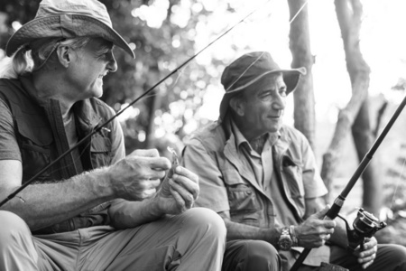 二个人拿着钓鱼棍子在自然, 钓鱼爱好概念, 黑白