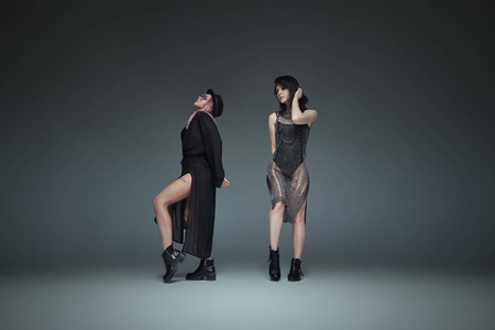 两个时髦的女孩穿着黑色时髦的衣服摆姿势