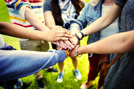 不同的朋友在团结的手堆叠照片