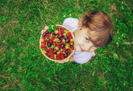 不同的自制夏天浆果在孩子的手。选择性聚焦