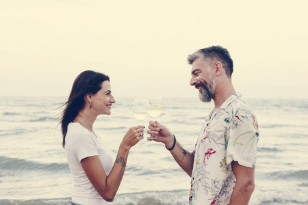 夫妇在海滩享用一杯酒