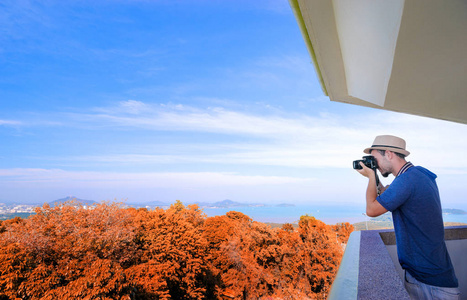 用一架照相机在旅行者拍照用照相机在风景点享受海,城市和天空照片