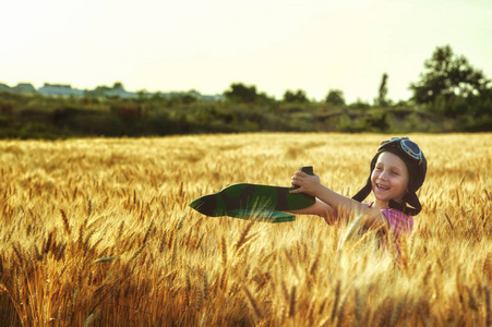 愉快的女孩在一个领域与麦子模型飞机