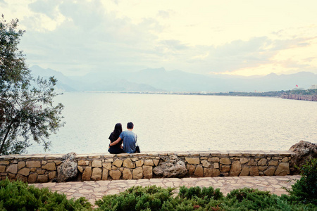 浪漫相爱的情侣站在一起, 在码头享受日落照片