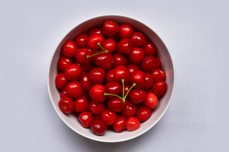一个白色的碗, 有成熟的和洗过的樱桃。顶部视图