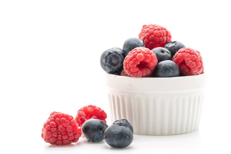 新鲜的覆盆子和新鲜的蓝莓在白色背景下分离