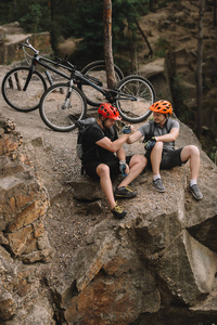 试骑和握手后在岩石悬崖上放松的年轻人的高角度观
