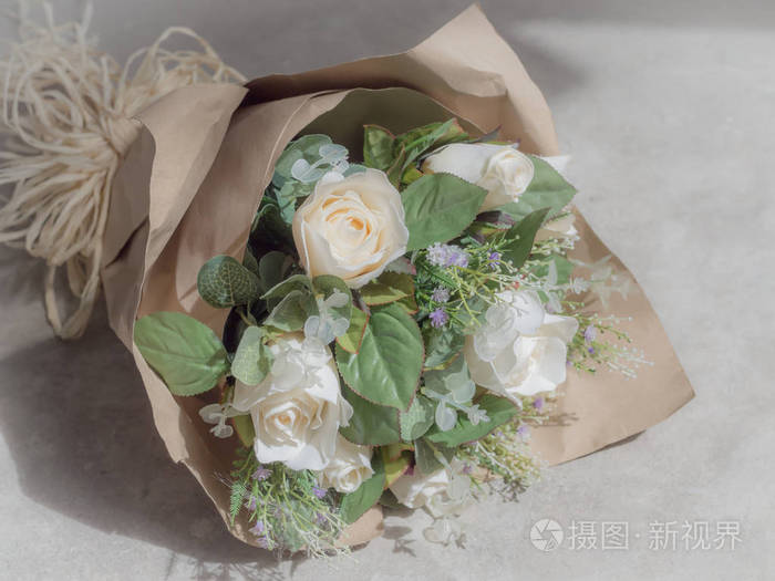 人造白玫瑰花束在包装棕色工艺纸上的具体背景照片 正版商用图片0ull2o 摄图新视界