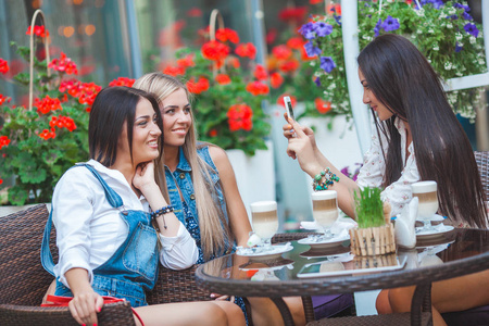 一群有吸引力的年轻妇女在咖啡馆做自拍和乐趣