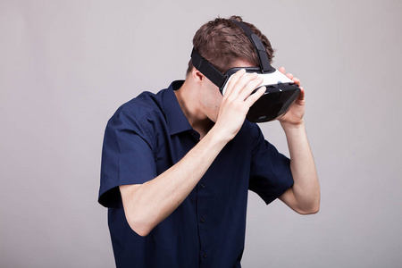 穿着休闲蓝衬衫的年轻人戴着 Vr 虚拟现实耳机