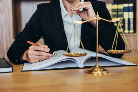 木制桌上的槌和女律师或法官在法庭主题司法和法律概念中的协议工作
