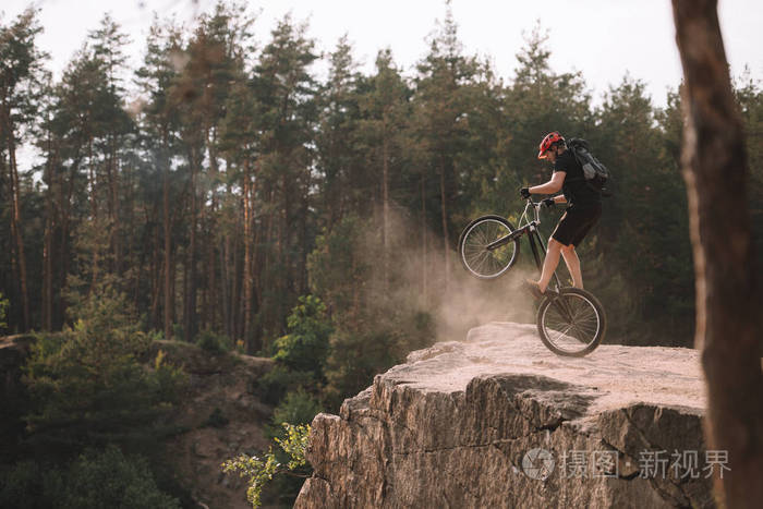 试骑自行车在后轮平衡在岩石室外