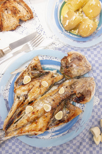 传统葡萄牙餐烤欧洲鲈鱼配马铃薯番茄沙拉特写