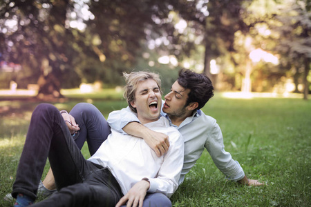 情侣在公园里玩, 躺在草地上享受夏日