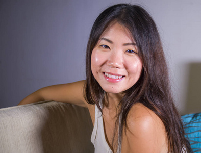 生活方式特写年轻美丽和快乐的亚洲华人妇女在家里沙发沙发上摆着欢快和甜美的肖像
