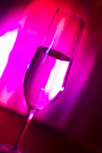 香槟汽酒玻璃普罗塞克静脉在 discotque 党酒吧婚礼期间, 在伊维萨西班牙与灯光背后