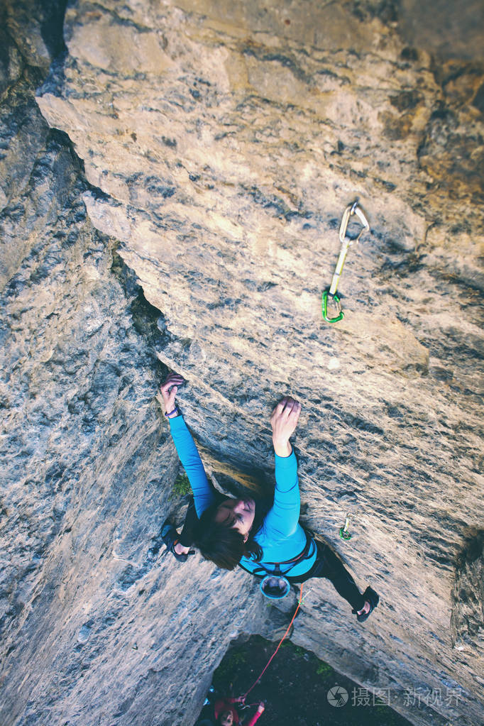 女人克服了艰难的攀登路线.岩石上的攀岩者.户外运动
