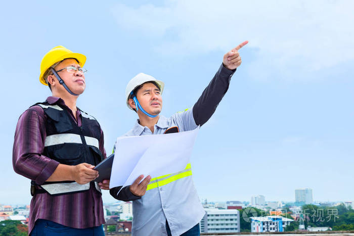 施工工程师与工头一起对施工现场工程进度进行了指点和探讨