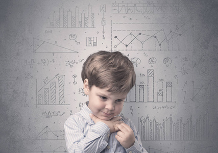 在灰色的墙前面的小男孩与图表和统计周围