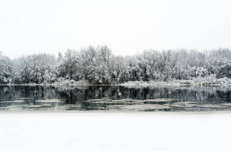 冬天的河水和树枝覆盖着白色的霜冻。冬天河风景