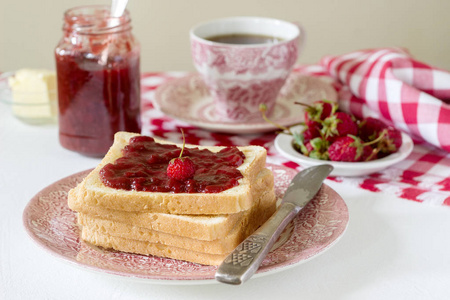 早餐面包用黄油和草莓大黄果酱敬酒, 配茶。质朴风格, 选择性聚焦