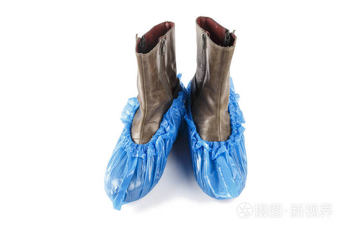 蓝色的医疗鞋盖在靴子上在白色背景上被隔离