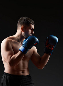 低关键工作室肖像英俊的肌肉战斗机在黑暗模糊背景下练习拳击