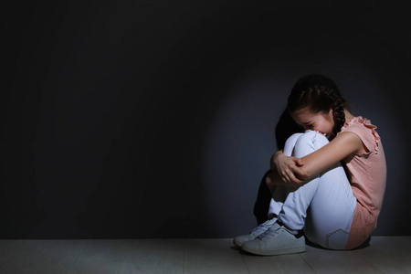 郁闷的小女孩坐在地板上.访问儿童心理学家的时间照片