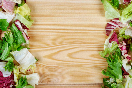 在木质背景下的新鲜绿色沙拉框架。健康的天然食物。食谱或菜单的样机