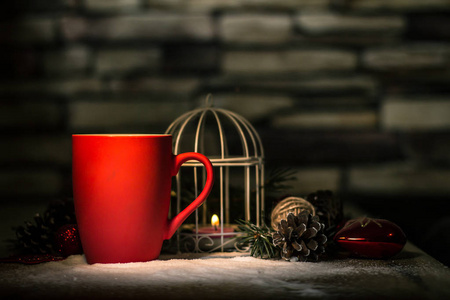 特写. 红色圣诞杯和节日桌上的蜡烛