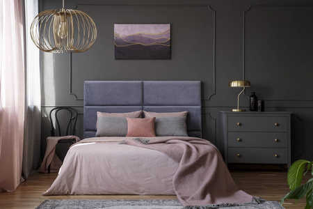 金色的灯在灰色的柜子旁边粉红色的床在优雅的粉彩卧室内饰椅