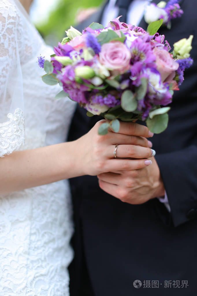 特写漂亮的 vioelt 花束在未婚妻和新郎手中