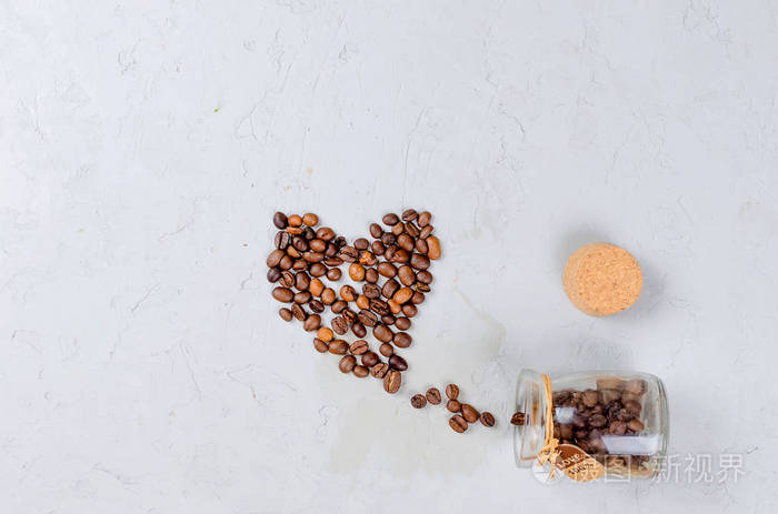 咖啡豆以心脏的形式在轻的具体背景。复制空间。顶部视图