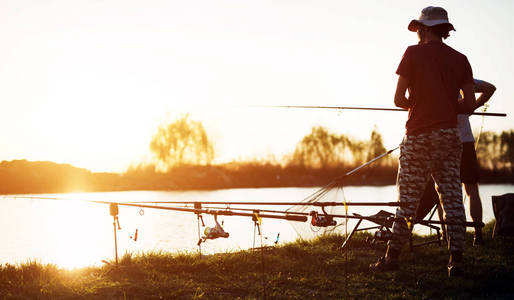 在日落钓鱼的男子
