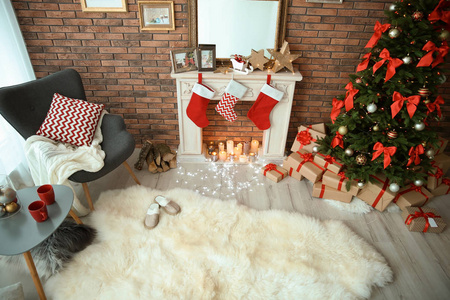 房间内饰与美丽的圣诞树和礼物附近装饰壁炉