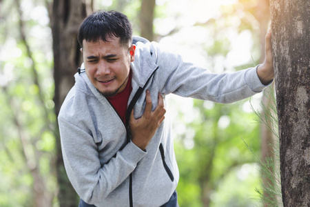 亚洲心脏骤停在公园里运行年轻人心脏病发作.严重心痛照片