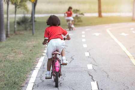 女孩骑自行车在交通规则在沥青路