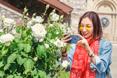 亚洲旅行妇女在庭院嗅到的白色玫瑰花