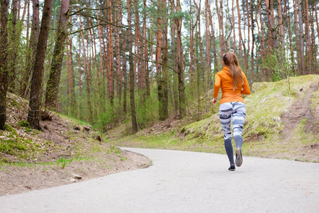 女孩在橙色 hoody 奔跑在森林里