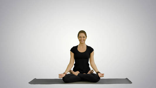 在白色背景下练习瑜伽的年轻女子冥想