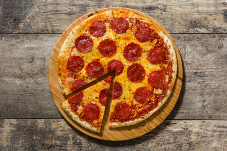 意大利辣香肠披萨在木桌上。顶部视图