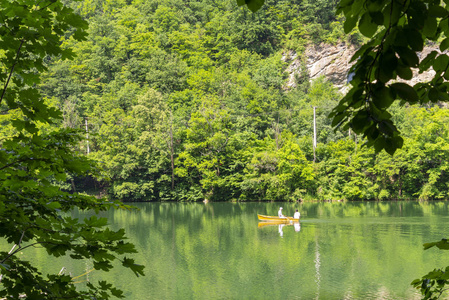 位于匈牙利 Miskolc 附近 Lillafured 的绿色 Hamori 湖。在山毛榉山的春天风景与面目全非人在小船