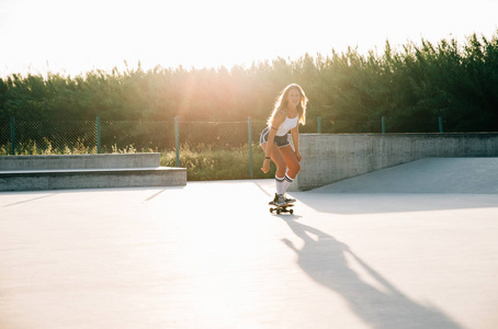 美丽的滑板女孩的生活方式在 skatepark 的时刻