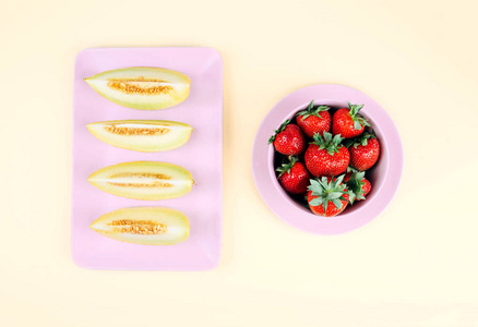 新鲜草莓在碗和 melone 在柔和的黄色背景