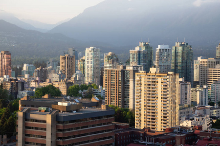 在阳光明媚的日落时分, 市中心城市的商业和住宅建筑鸟瞰图。在加拿大不列颠哥伦比亚省温哥华拍摄