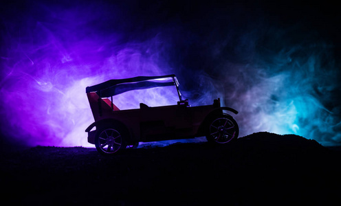 老老式汽车的剪影在黑暗的雾色调背景与发光灯在低光。选择性聚焦