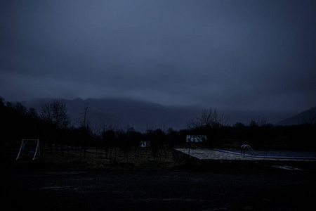 人的剪影站在黑暗的森林与光.雾时森林里的黑夜.梦幻般的夜森林场面.