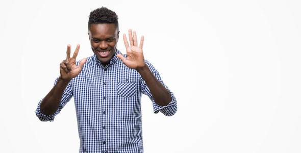 年轻的非洲裔美国人身穿蓝色衬衫显示和指向八的手指, 而微笑着自信和快乐