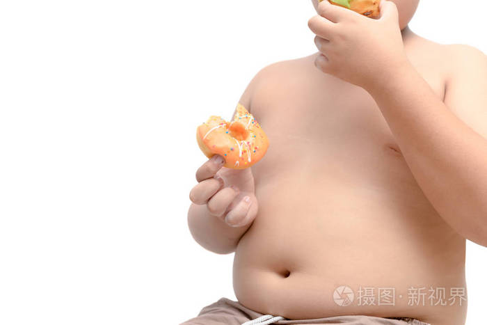 肥胖男孩拿着吃甜甜圈在白色背景, 垃圾食品和节食概念分离