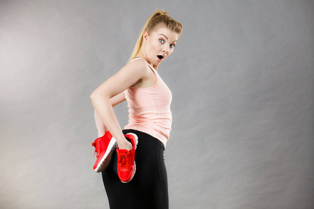 快乐运动微笑女人展示运动服运动鞋红鞋，舒适的鞋子适合锻炼和培训